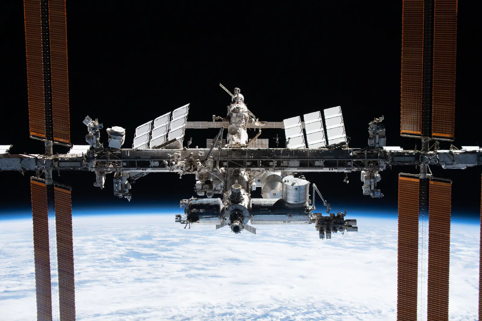 The International Space Station photographed against the blackness of space from the departing SpaceX Crew Dragon Endeavour, its solar arrays and truss fully extended.