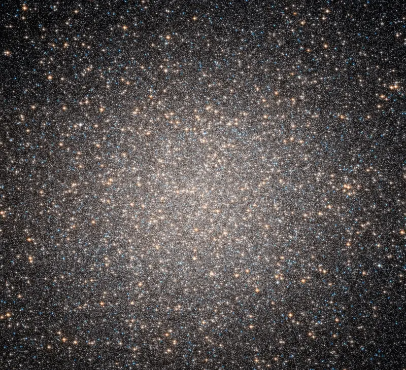 The globular cluster Omega Centauri: a dense ball of hundreds of thousands of stars, yellow-white elders mixed with a scattering of hot blue ones.