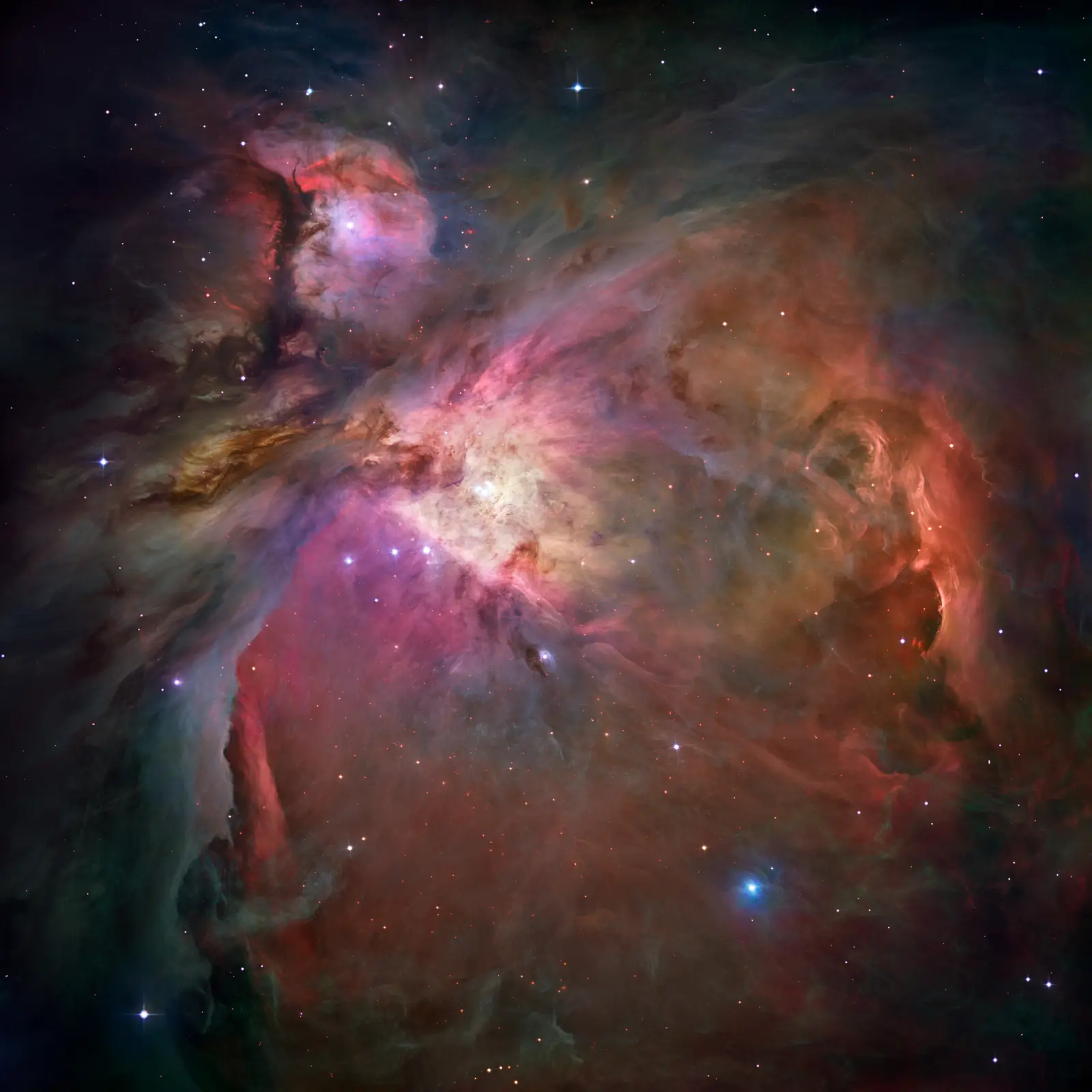The Orion Nebula: a vast pink and gold cavern of glowing gas carved open by the four bright Trapezium stars at its heart.