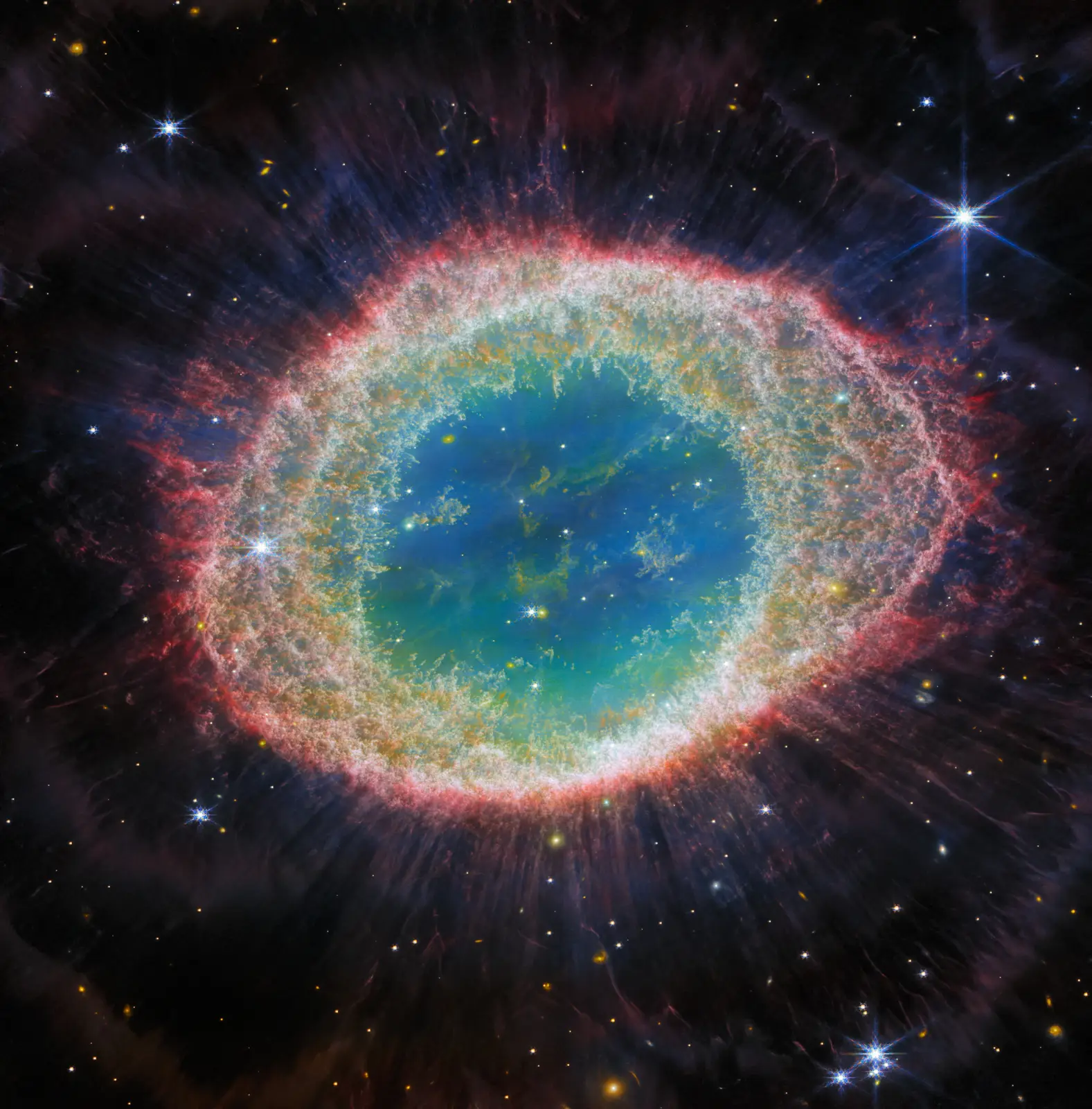 Webb’s NIRCam view of the Ring Nebula: a bright oval of intricately structured gas with a fringe of fine spikes, and the dying white dwarf at its centre.